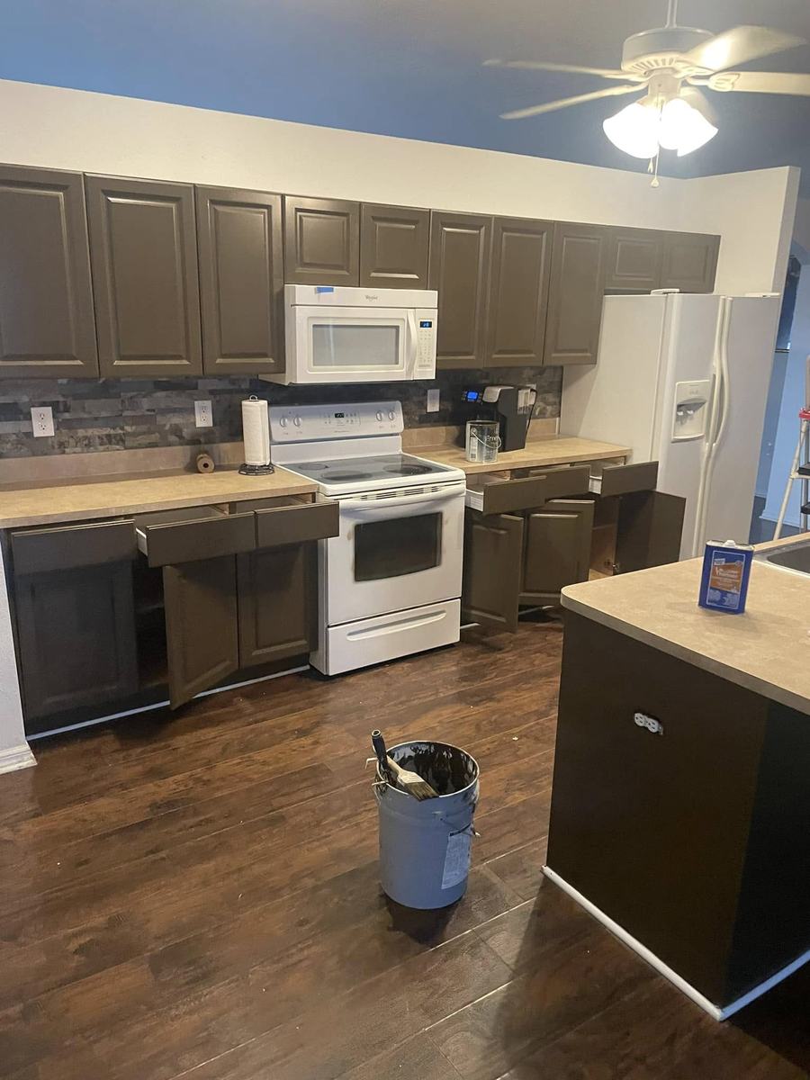 Kitchen cabinet refinishing in progress &mdash; doors off, fresh painted finish