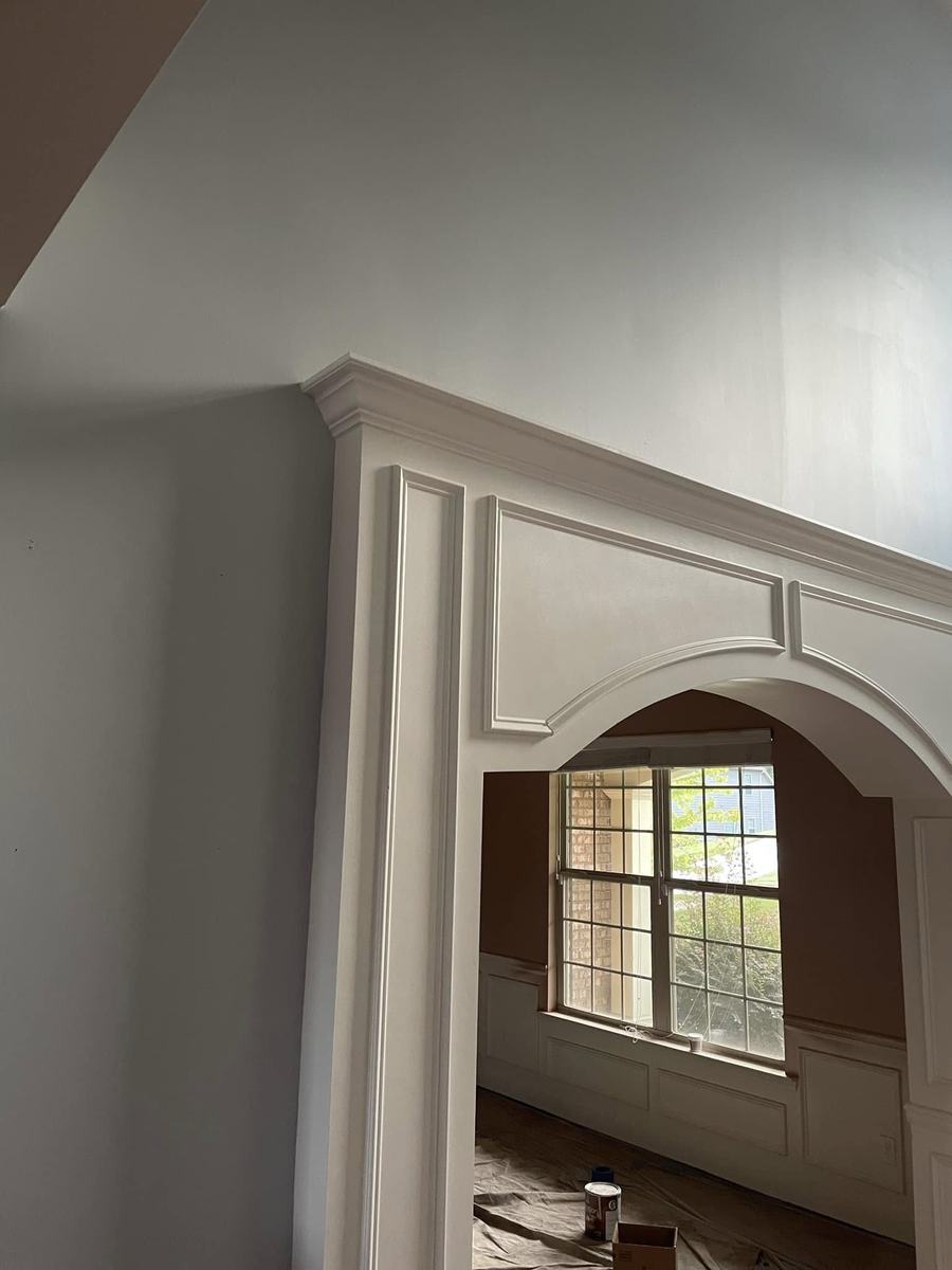 Freshly painted archway trim and crown detail over a window